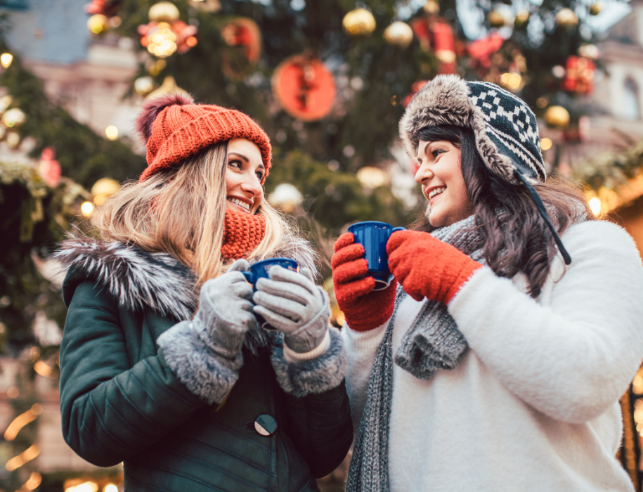 Two women holding cups outside